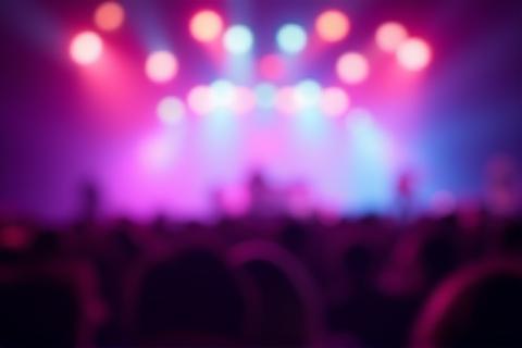 Stage lights over a music concert crowd